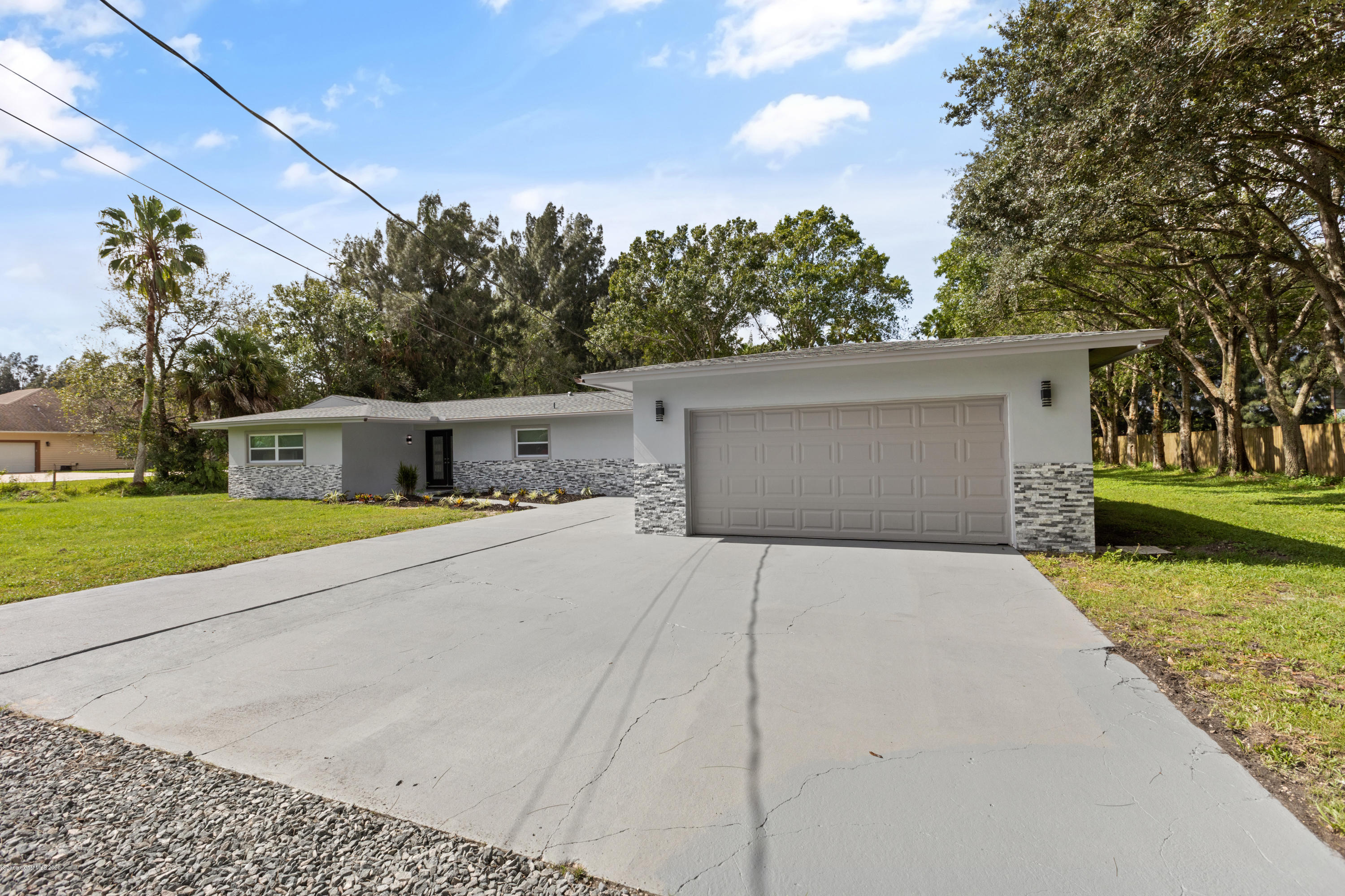 1790 Harlock Road Melbourne, FL 32934 - Photo 2 of 47 a front view of a house with a yard and a garage