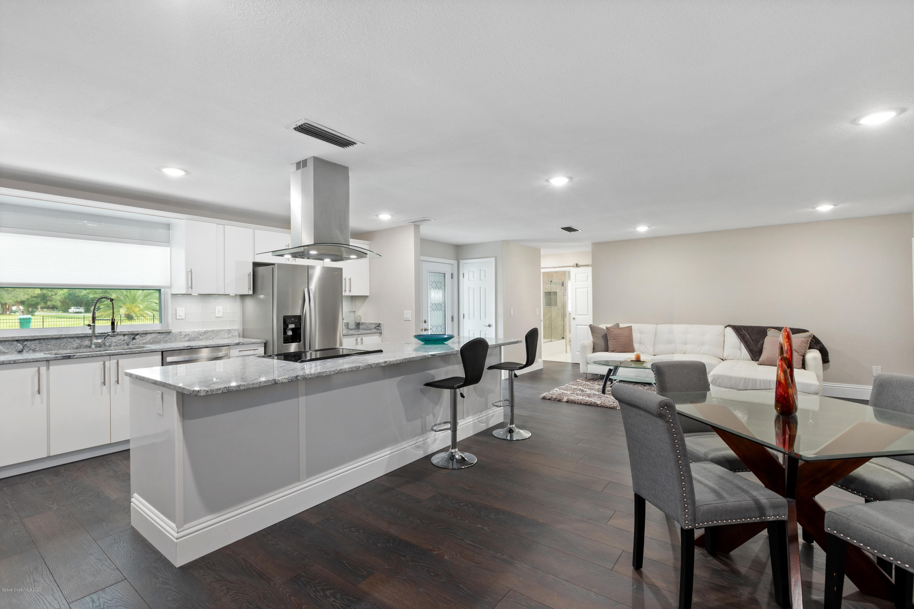 1790 Harlock Road Melbourne, FL 32934 - Photo 11 of 47 a kitchen with a dining table chairs stove a sink and dishwasher