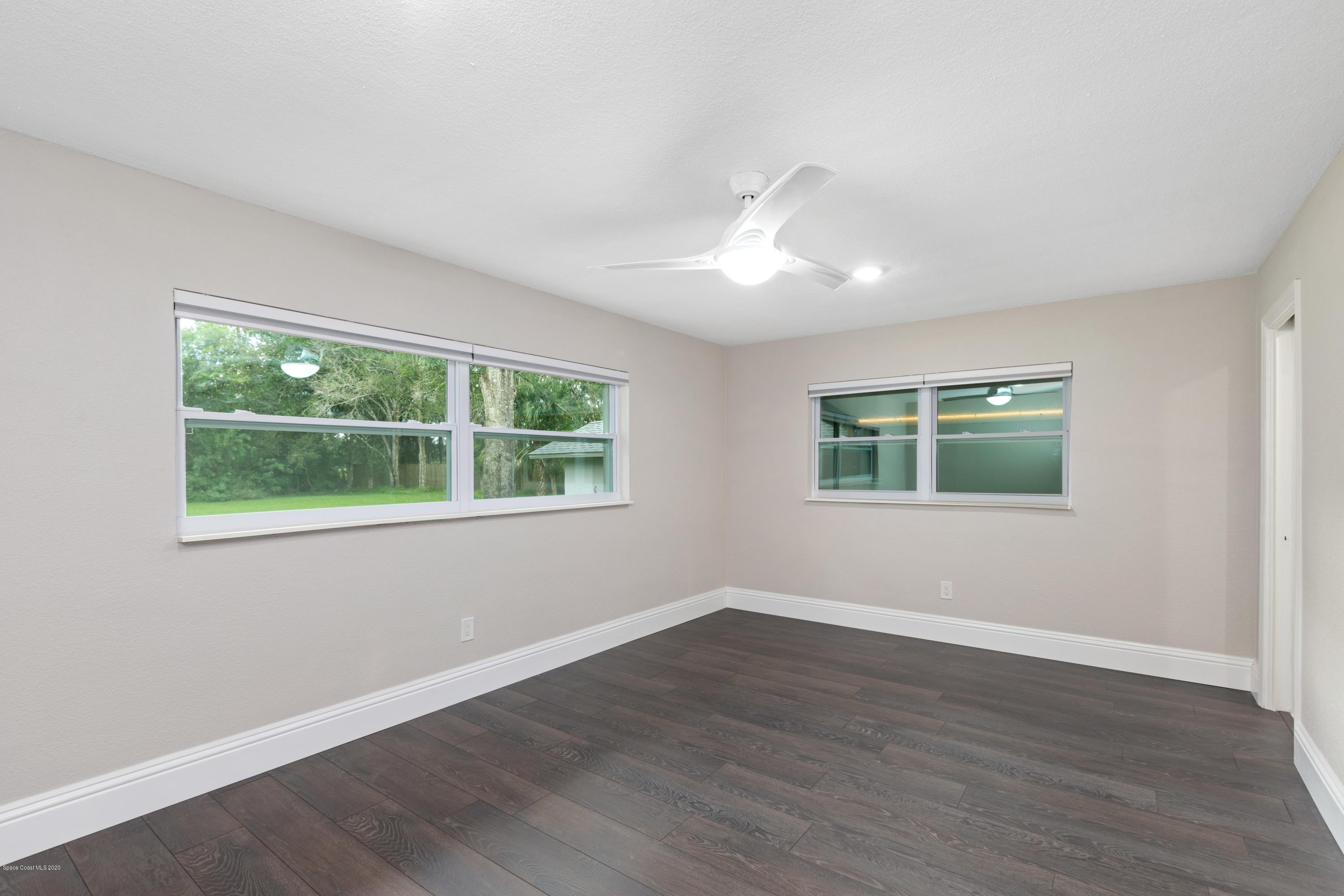 1790 Harlock Road Melbourne, FL 32934 - Photo 26 of 47 a view of an empty room with wooden floor and a window