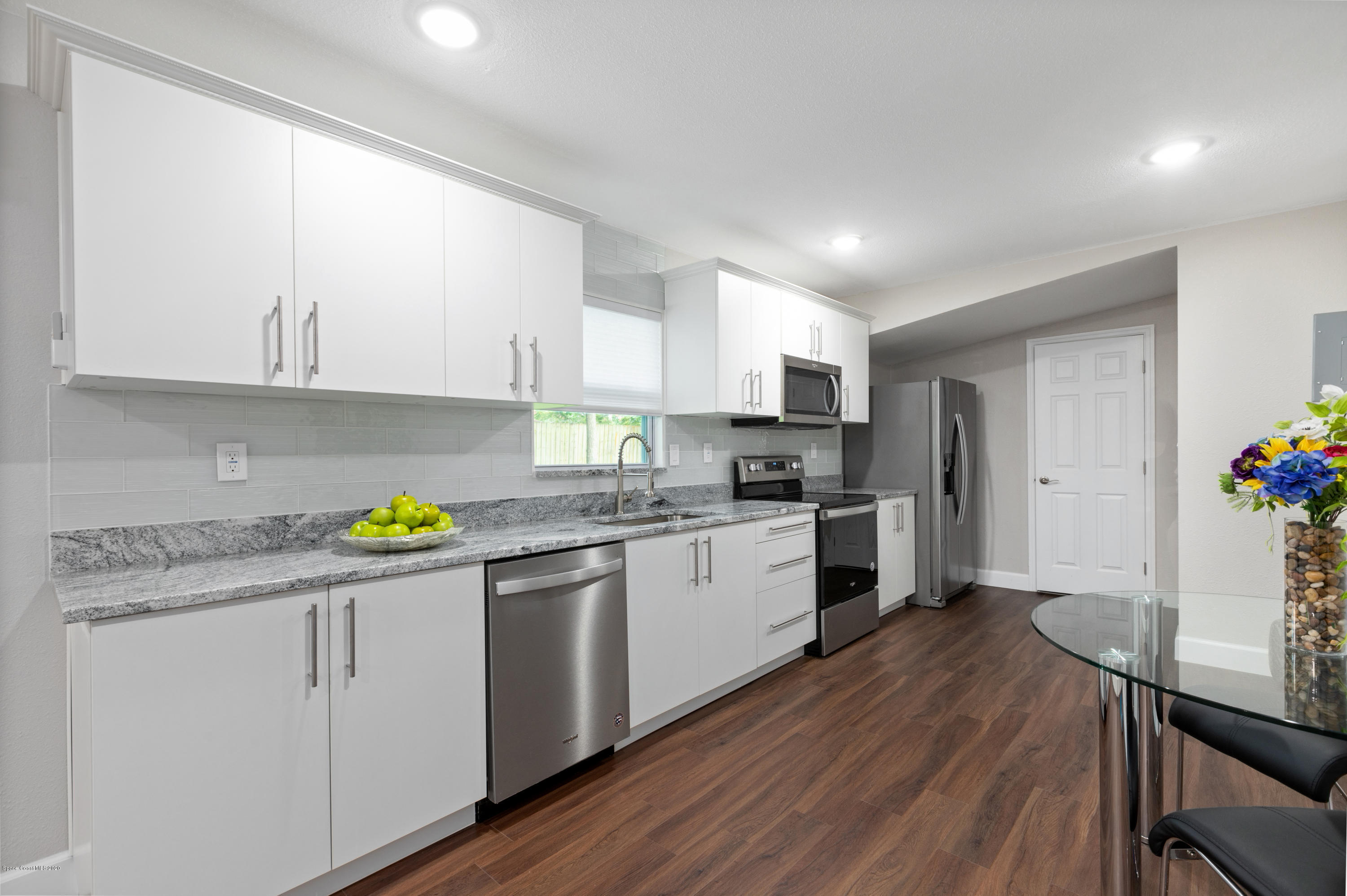 1790 Harlock Road Melbourne, FL 32934 - Photo 39 of 47 a kitchen with granite countertop white cabinets and white appliances