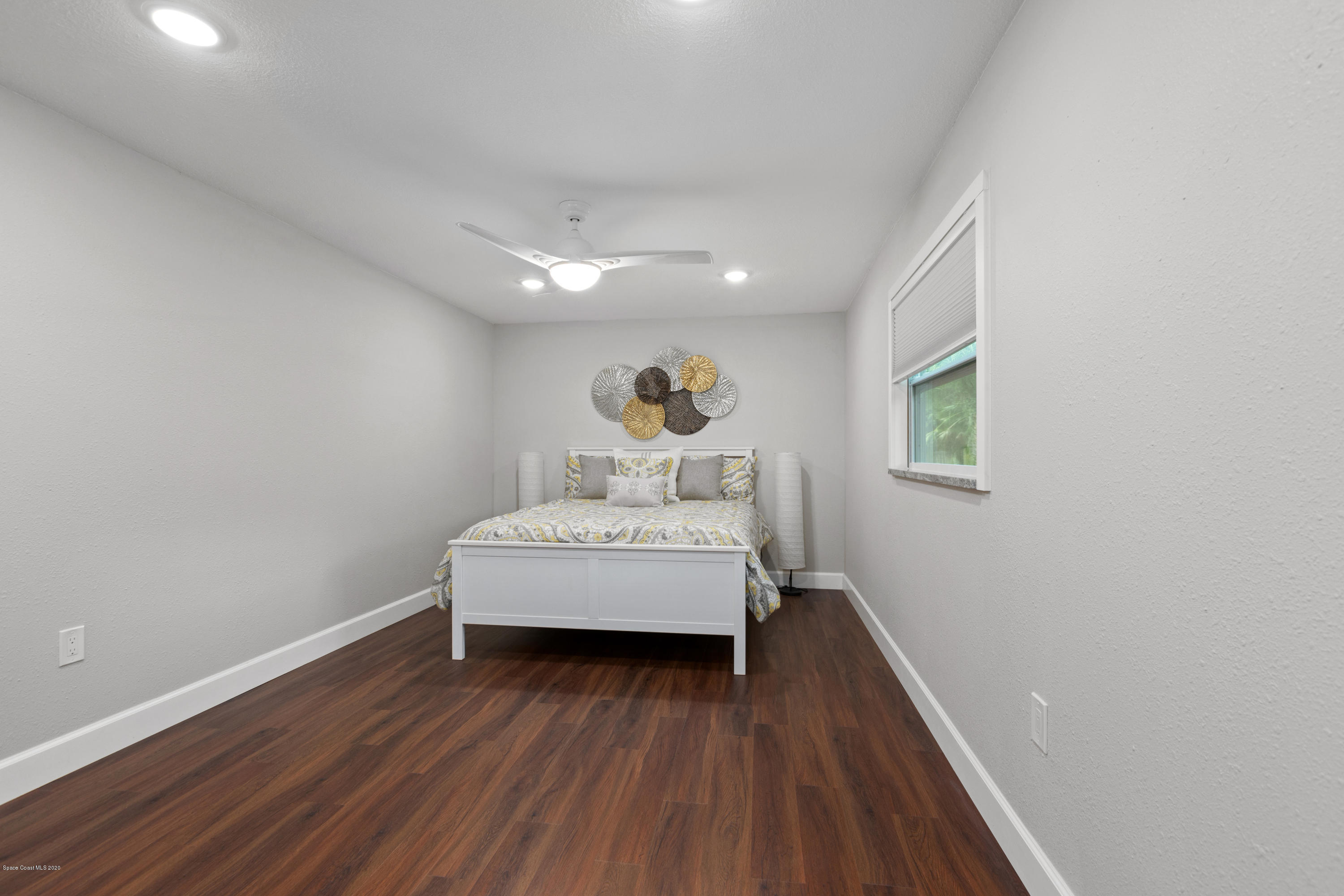 1790 Harlock Road Melbourne, FL 32934 - Photo 41 of 47 a bedroom with a bed and wooden floor