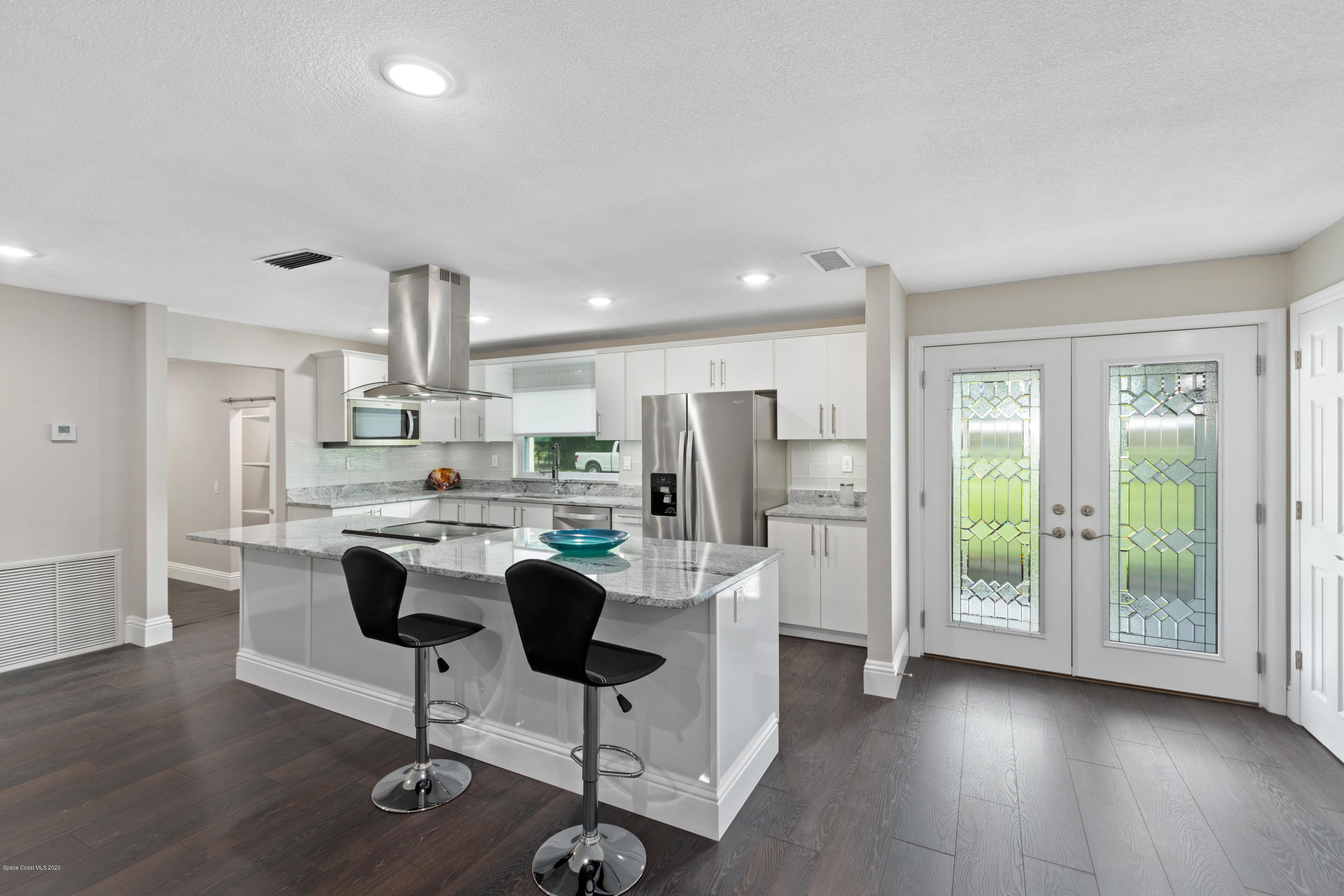 1790 Harlock Road Melbourne, FL 32934 - Photo 7 of 47 a kitchen with stainless steel appliances kitchen island hardwood floor and a refrigerator