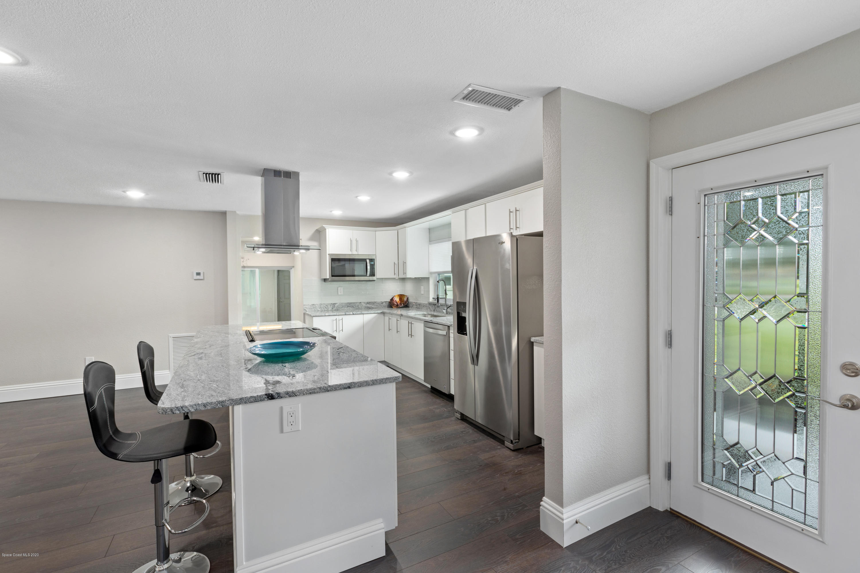 1790 Harlock Road Melbourne, FL 32934 - Photo 10 of 47 a kitchen with stainless steel appliances kitchen island granite countertop a refrigerator and a stove top oven