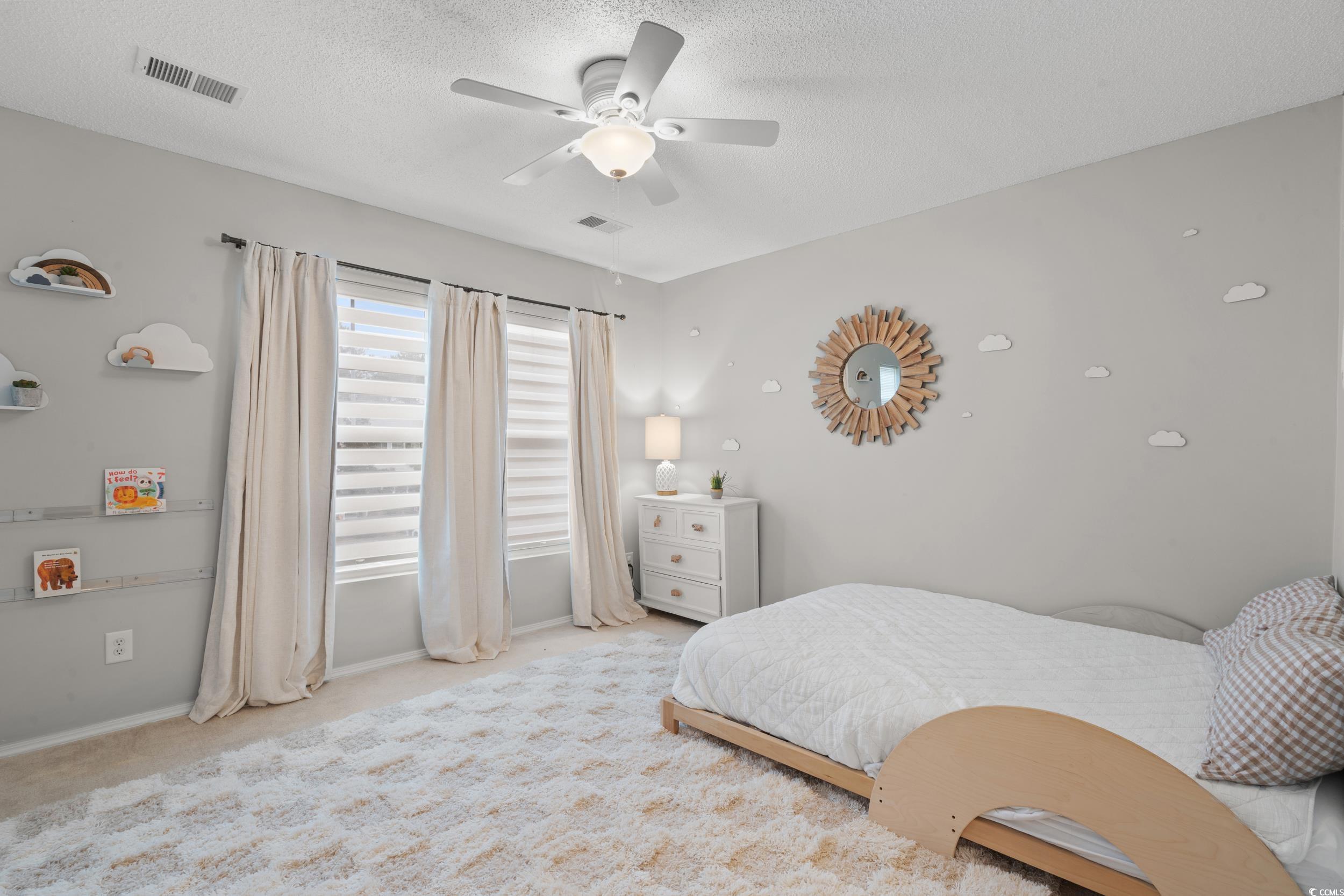 104 Olde Towne Way, Unit 5 Myrtle Beach, SC 29588 - Photo 13 of 24 Bedroom featuring light carpet, a ceiling fan, and a textured ceiling