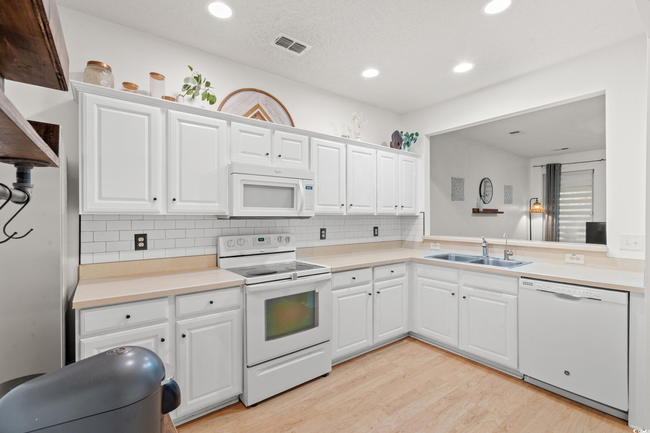 104 Olde Towne Way, Unit 5 Myrtle Beach, SC 29588 - Photo 7 of 24 Kitchen with white appliances, light countertops, white cabinetry, light wood-style flooring, and recessed lighting