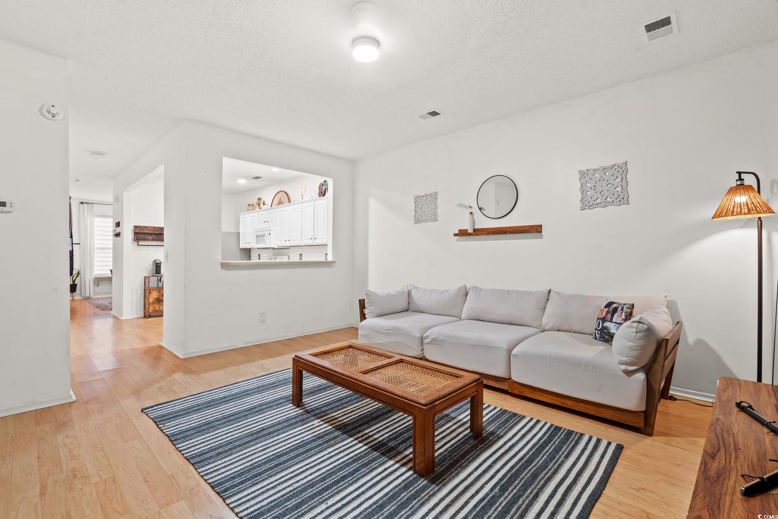 104 Olde Towne Way, Unit 5 Myrtle Beach, SC 29588 - Photo 10 of 24 Living room featuring light wood finished floors and a textured ceiling