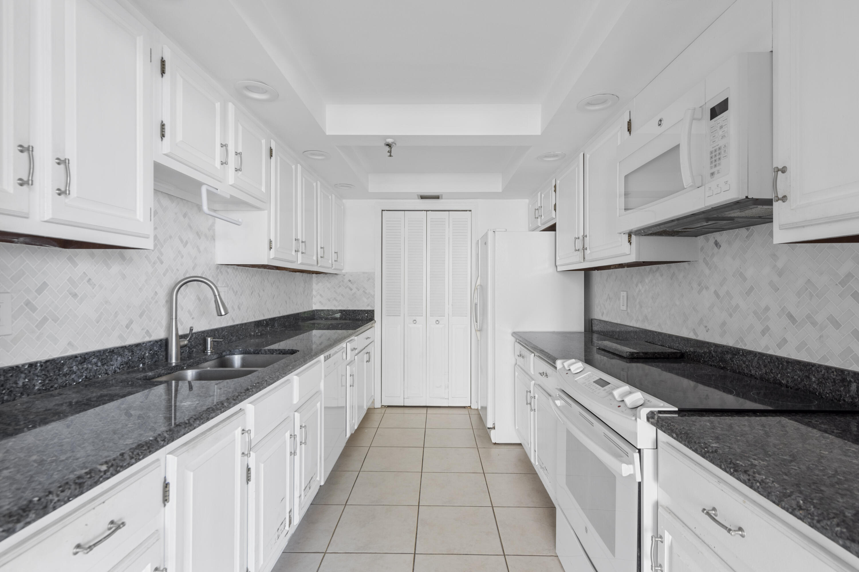859 Jeffery Street, Unit 312 Boca Raton, FL 33487 - Photo 1 of 53 a kitchen with granite countertop white cabinets and stainless steel appliances