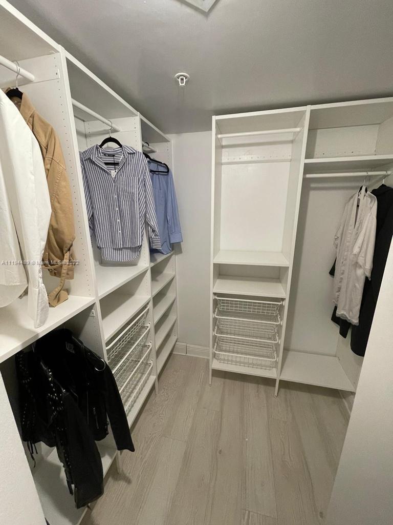 185 Southwest 7th Street, Unit 2703 Miami, FL 33130 - Photo 12 of 16 a view of walk in closet with clothes and shoes