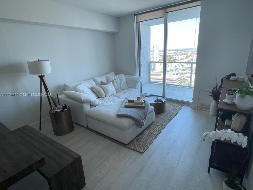185 Southwest 7th Street, Unit 2703 Miami, FL 33130 - Photo 2 of 16 a living room with furniture and a window