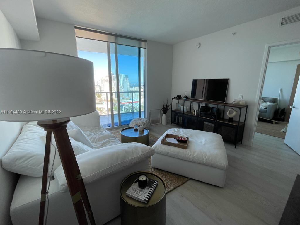 185 Southwest 7th Street, Unit 2703 Miami, FL 33130 - Photo 3 of 16 a living room with furniture and a flat screen tv