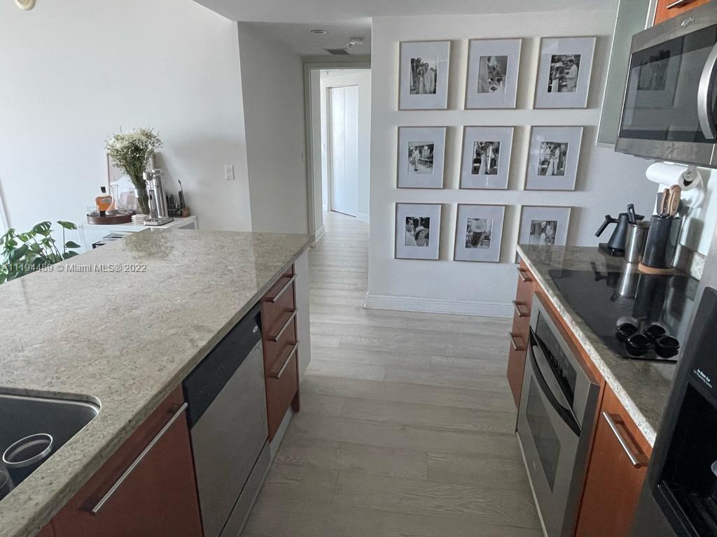 185 Southwest 7th Street, Unit 2703 Miami, FL 33130 - Photo 7 of 16 a kitchen with cabinets and stove