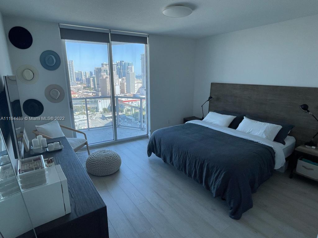 185 Southwest 7th Street, Unit 2703 Miami, FL 33130 - Photo 9 of 16 a bedroom with a bed and glass door