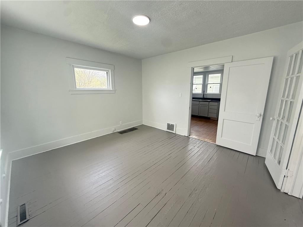 726 Baldwin Avenue Sharon, PA 16146 - Photo 3 of 11 an empty room with wooden floor and windows