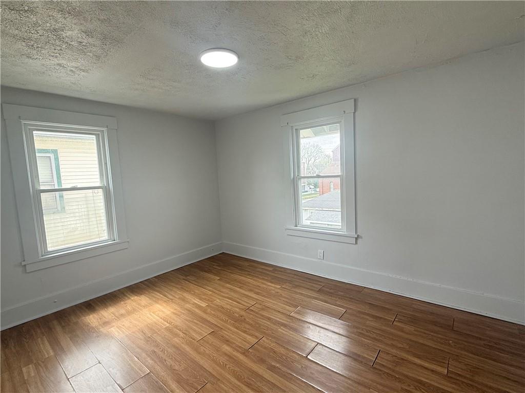 726 Baldwin Avenue Sharon, PA 16146 - Photo 7 of 11 a view of an empty room with wooden floor and a window