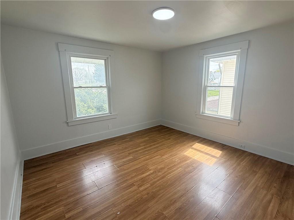 726 Baldwin Avenue Sharon, PA 16146 - Photo 9 of 11 an empty room with wooden floor and windows