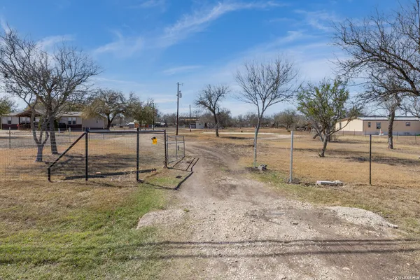 a view of a yard with wooden fence