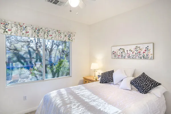 a bedroom with a bed and a painting on the wall