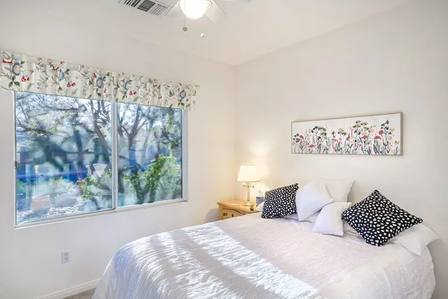 a bedroom with a bed and a painting on the wall