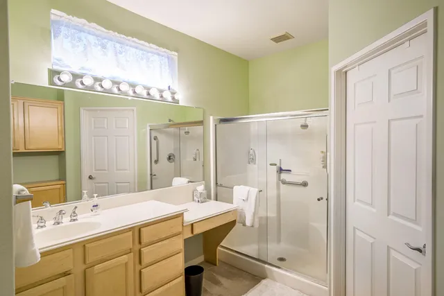 a bathroom with a shower sink and mirror