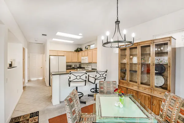a view of a kitchen with kitchen island stainless steel appliances wooden floor dining table and chairs