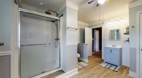 a spacious bedroom with a bed next to a large window with wooden floor