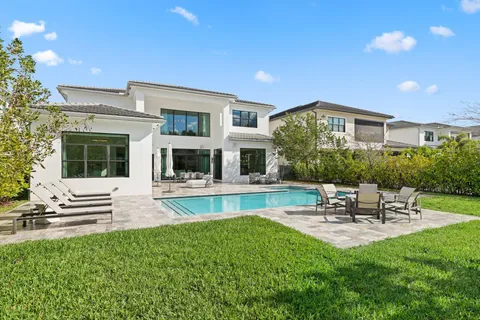 a large white kitchen with stainless steel appliances kitchen island granite countertop a stove and a sink