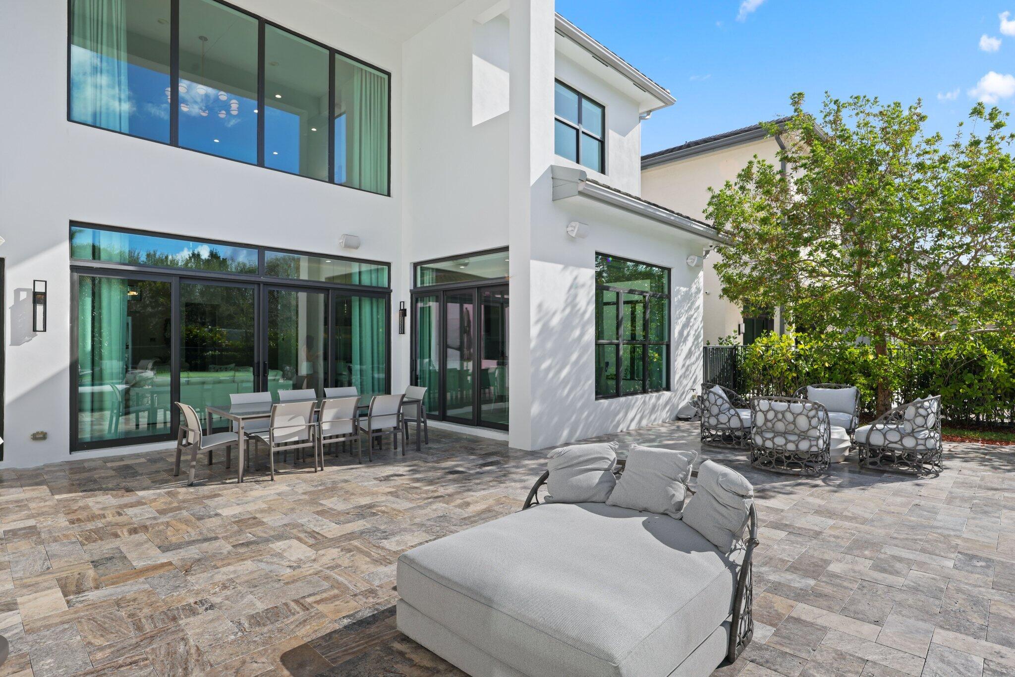 17432 Ponte Chiasso Drive Boca Raton, FL 33496 - Photo 85 of 116 a view of a patio with couches table and chairs and potted plants