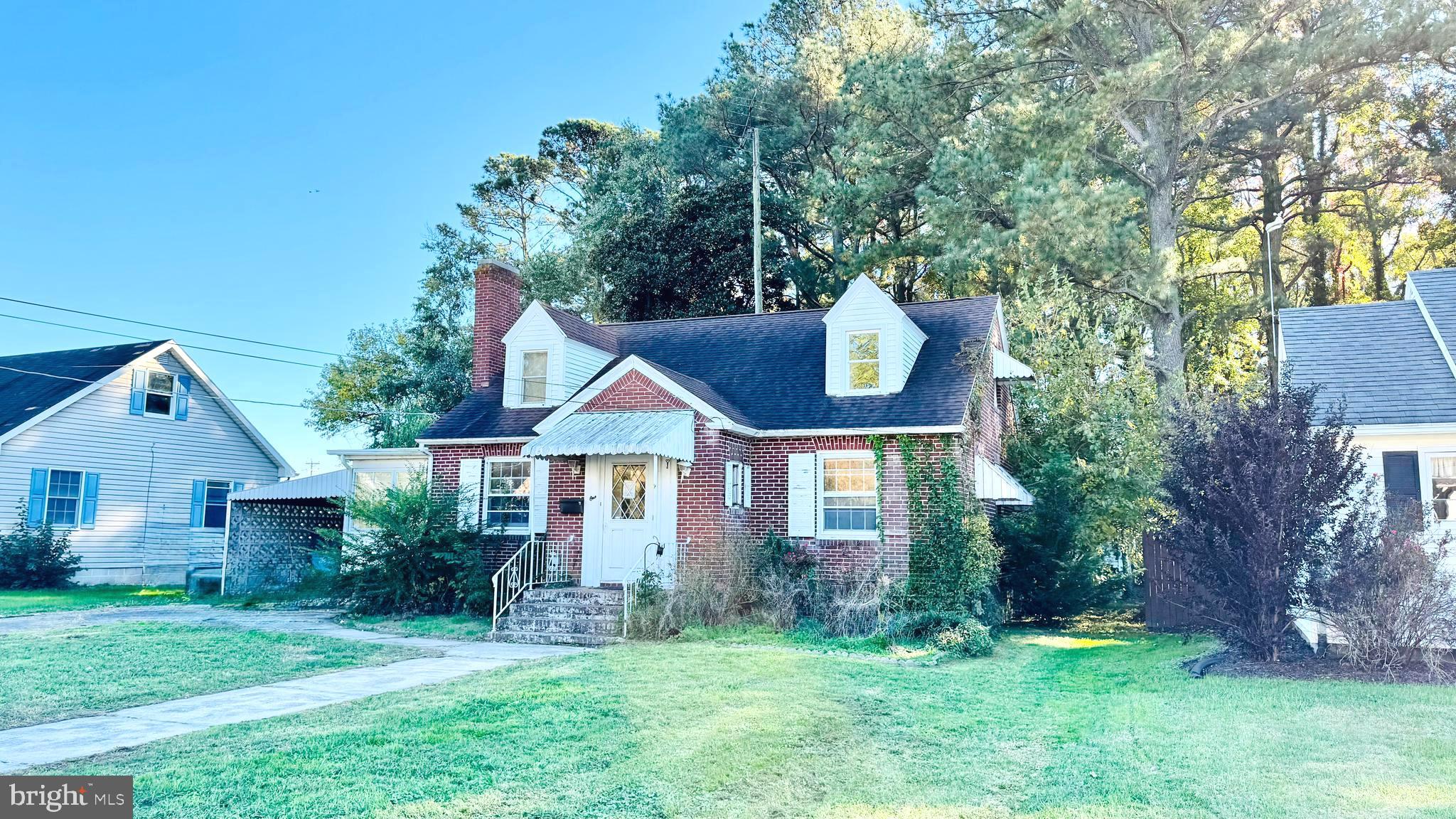 a front view of a house with a yard and trees