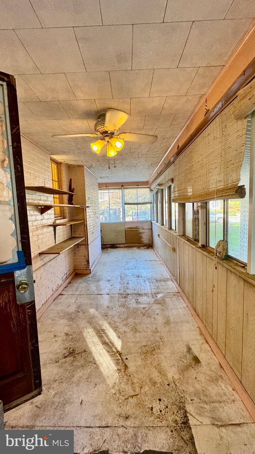 1 Potomac Street Crisfield, MD 21817 - Photo 14 of 15 a view of a living room with a fireplace furniture and a kitchen view
