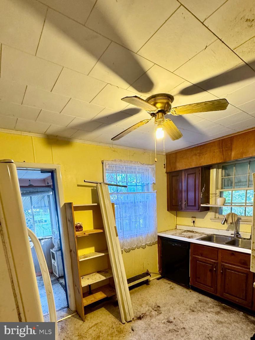 1 Potomac Street Crisfield, MD 21817 - Photo 5 of 15 a kitchen with a sink and wooden cabinets
