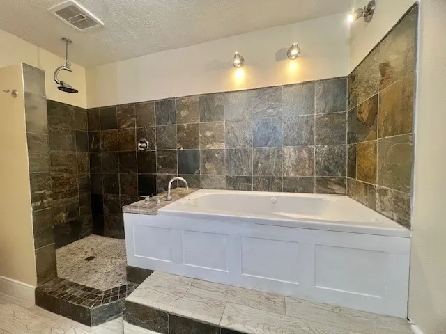 a bathroom with a bathtub and shower