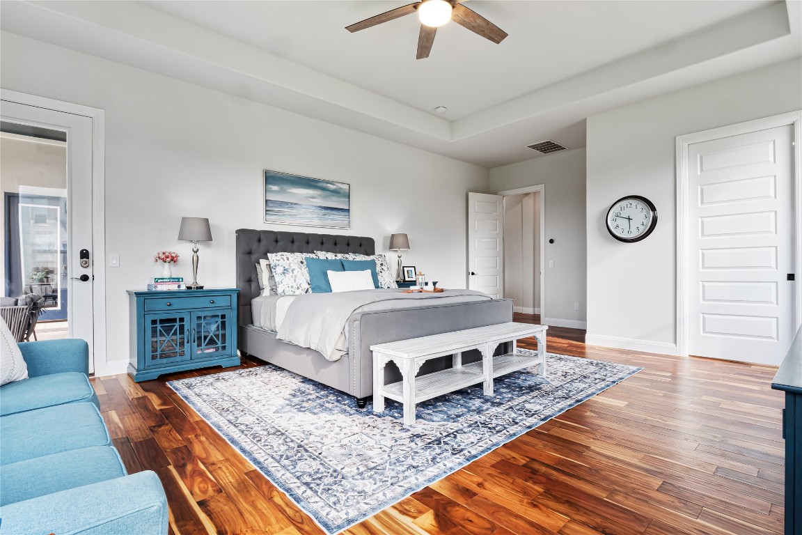 504 Loyal June Trail Leander, TX 78641 - Photo 11 of 16 a bedroom with a bed a dresser and wooden floor