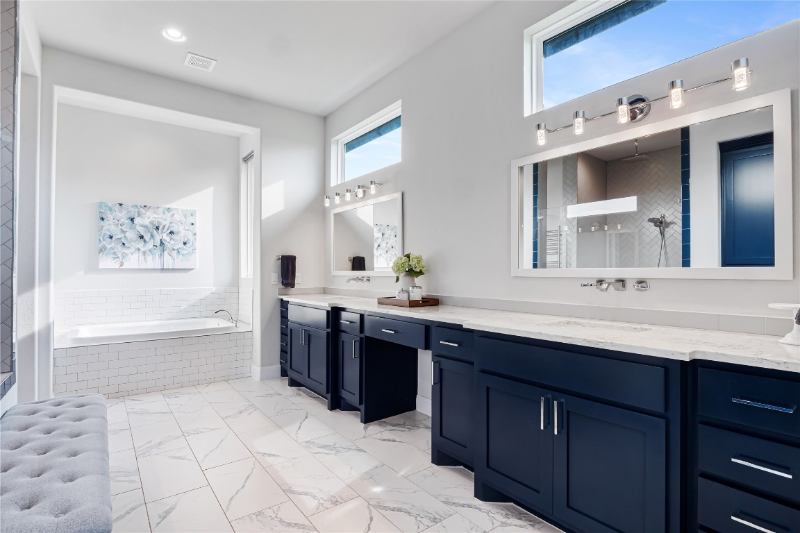 504 Loyal June Trail Leander, TX 78641 - Photo 12 of 16 a spacious bathroom with a bathtub sink and mirror