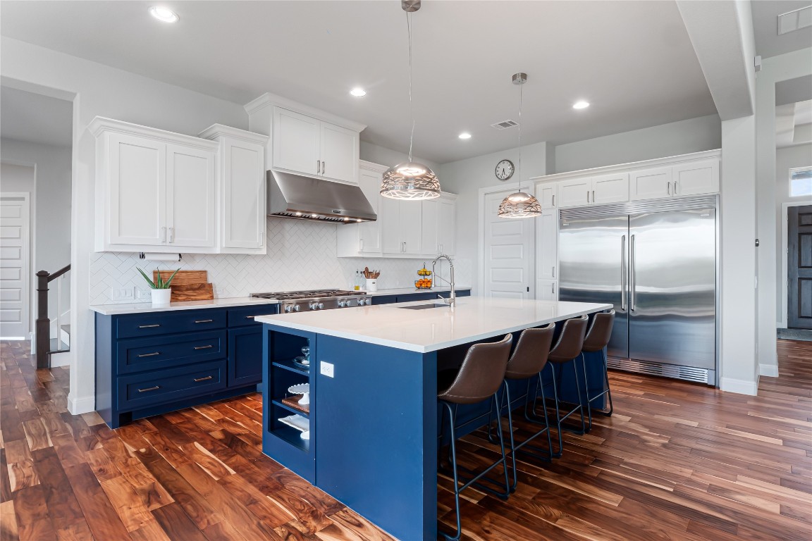 504 Loyal June Trail Leander, TX 78641 - Photo 3 of 16 a kitchen with stainless steel appliances granite countertop a sink a stove and a refrigerator