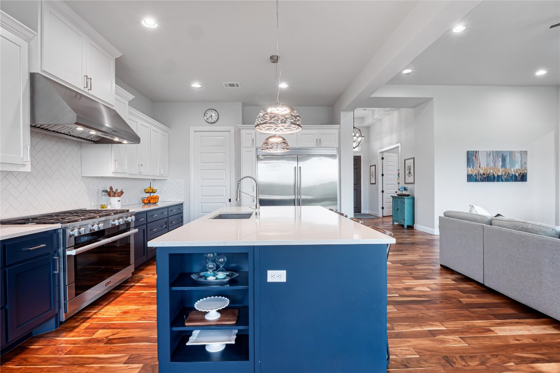 504 Loyal June Trail Leander, TX 78641 - Photo 16 of 16 a large kitchen with stainless steel appliances granite countertop a sink dishwasher stove and oven with wooden floor