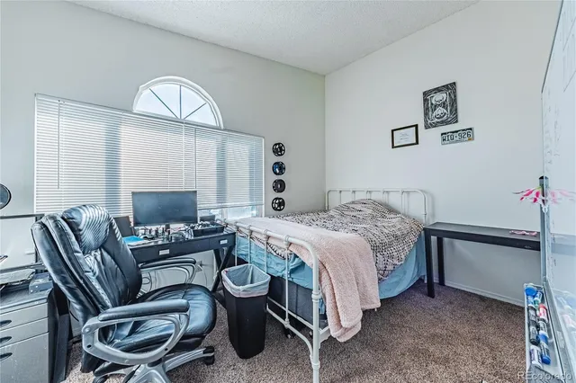 a bedroom with a bed mirror and a window