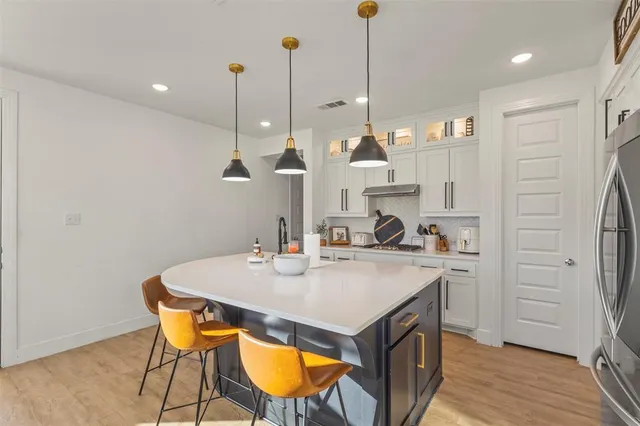 a view of a kitchen with a sink a refrigerator a stove and wooden floor
