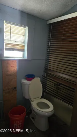a white toilet sitting next to a window