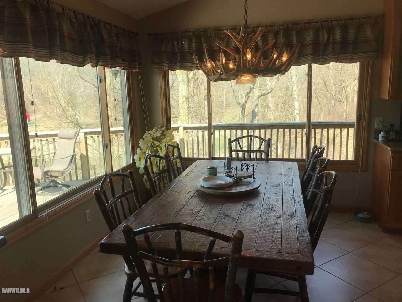 9034 South Gamble Hill Road Elizabeth, IL 61028 - Photo 4 of 24 a view of a dining room with furniture large windows and wooden floor