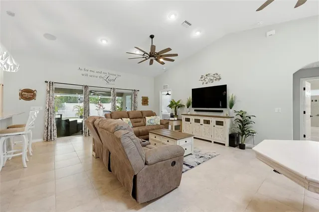 a living room with furniture kitchen view and a large window