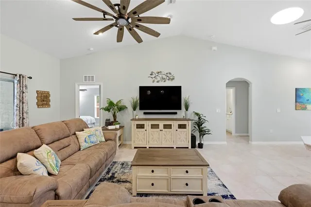 a kitchen with stainless steel appliances a refrigerator a stove top oven a sink dishwasher and white cabinets with wooden floor