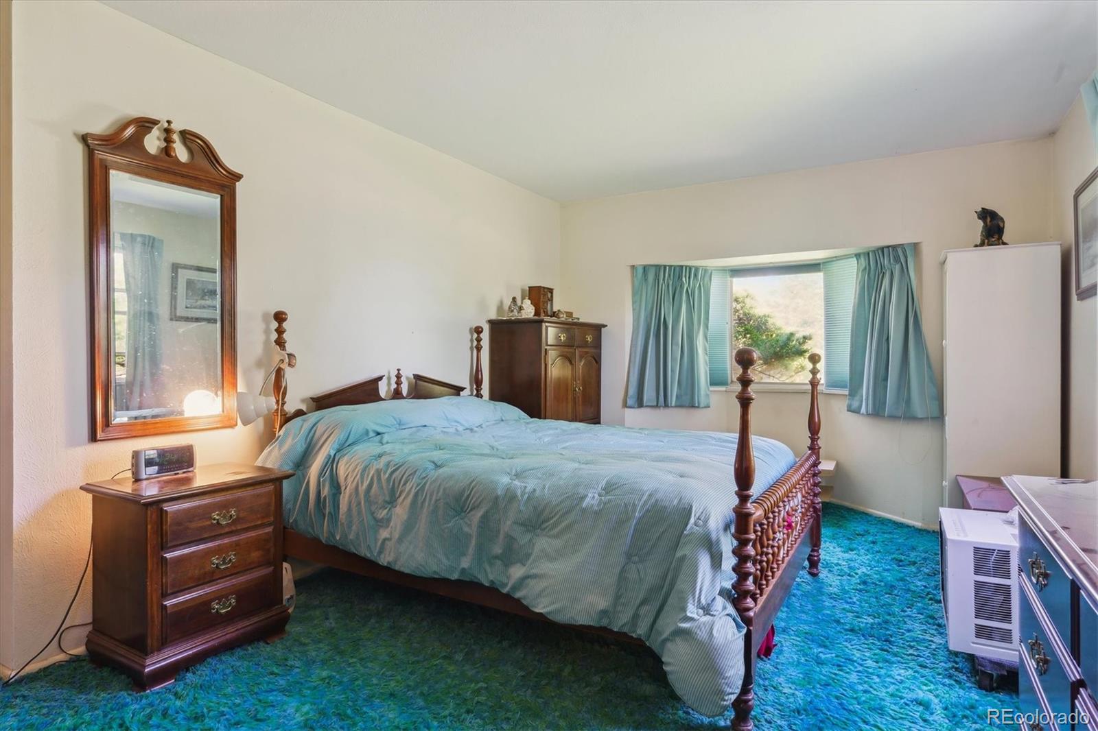 2938 West Wolfensberger Road Sedalia, CO 80135 - Photo 32 of 50 a bed room with a bed and a mirror