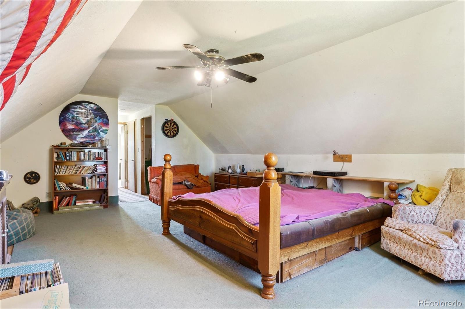 2938 West Wolfensberger Road Sedalia, CO 80135 - Photo 36 of 50 a bedroom with a bed and a chandelier