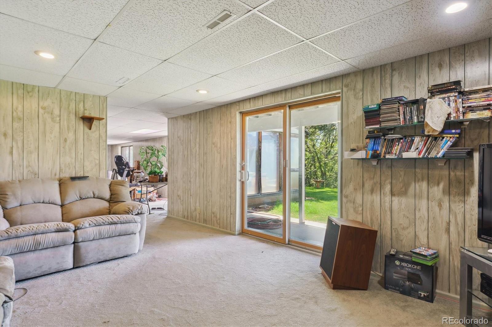 2938 West Wolfensberger Road Sedalia, CO 80135 - Photo 39 of 50 a living room with furniture a ceiling fan and a window