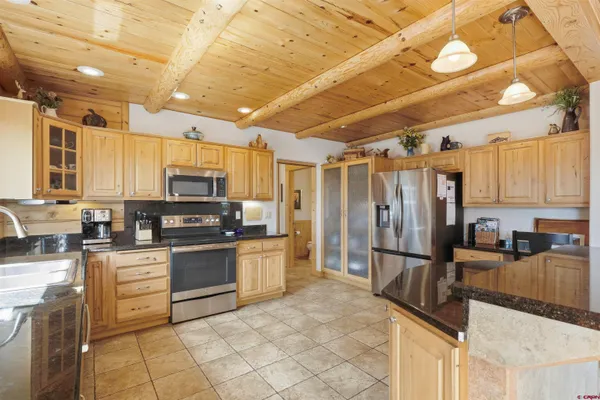 a kitchen with stainless steel appliances granite countertop a refrigerator a stove top oven a sink and dishwasher