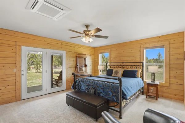 a spacious bedroom with a bed couch and a large window