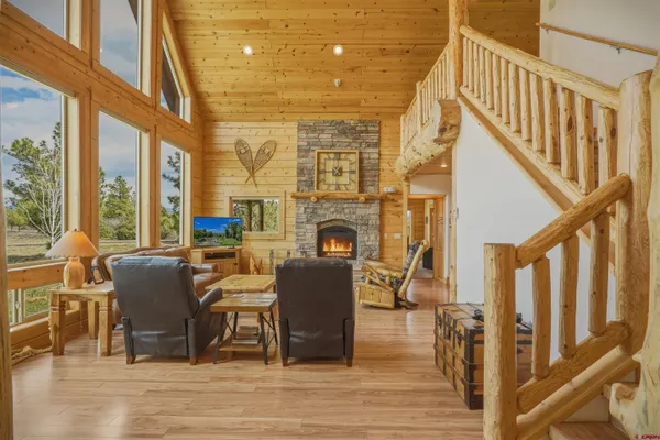 a living room with furniture a fireplace and a floor to ceiling window