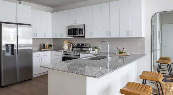 a kitchen with stainless steel appliances granite countertop a sink refrigerator and cabinets