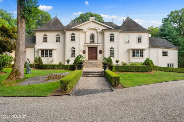 a kitchen with stainless steel appliances kitchen island granite countertop a table chairs sink and cabinets