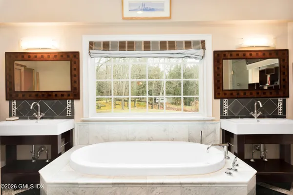 a bathroom with a double vanity sink mirror double and bathtub
